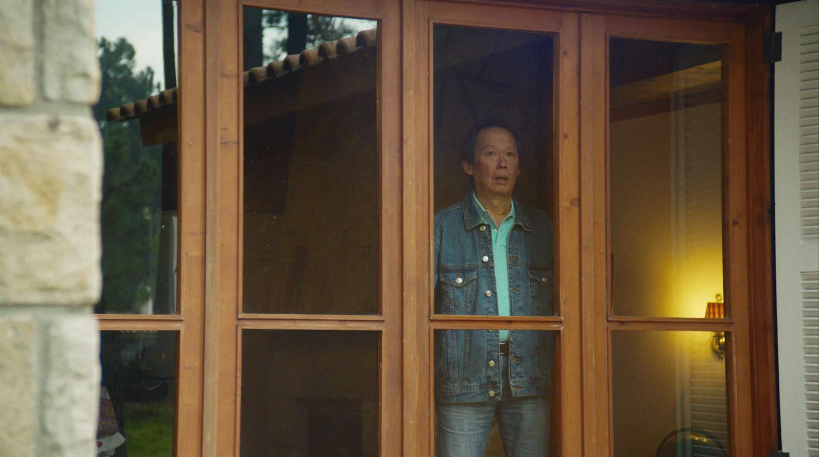 a woman is looking out of a window