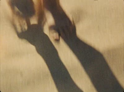 the shadow of a person's feet on a bed