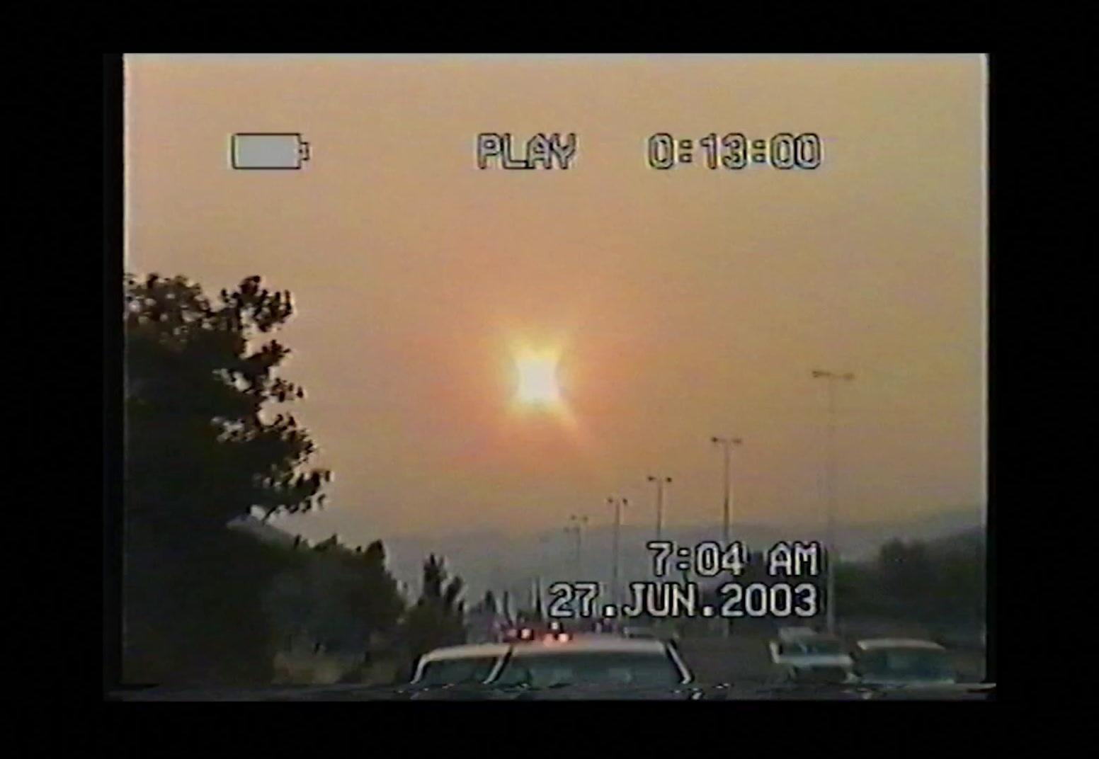 the sun is setting over a parking lot