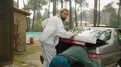 a man with a beard and a beard standing next to a car