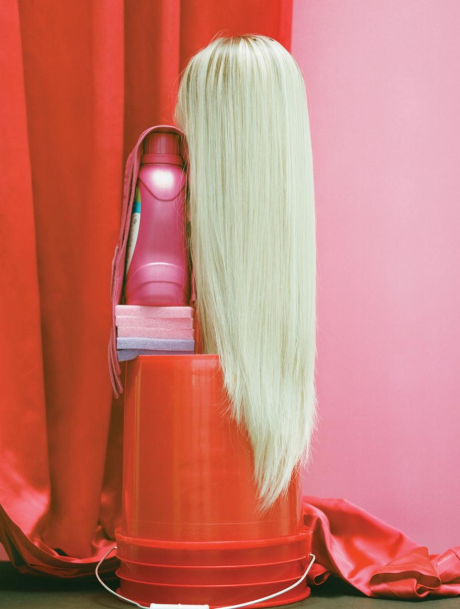 a hair dryer sitting on top of a table next to a red curtain