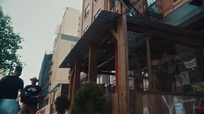 a man walking down a street next to a tall building