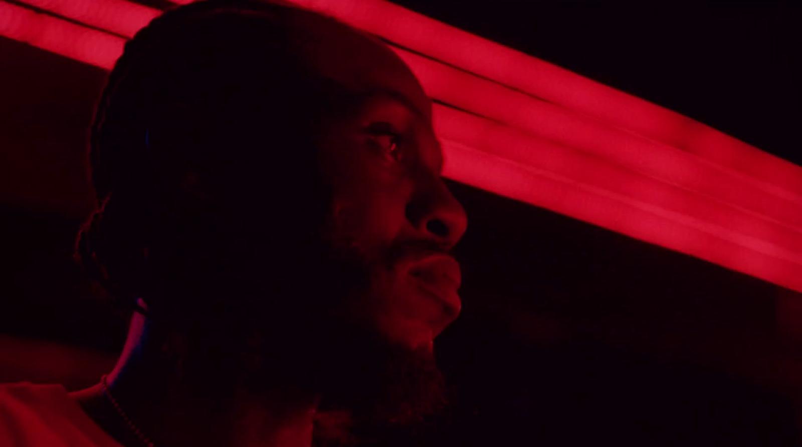 a man standing in front of a red light