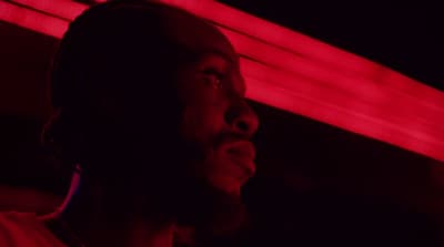 a man standing in front of a red light