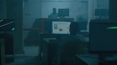 a man sitting in front of a computer monitor