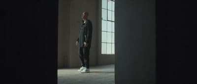 a man standing in front of a window in a dark room