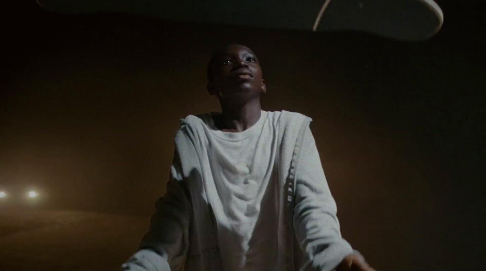 a man standing in the dark with his arms outstretched