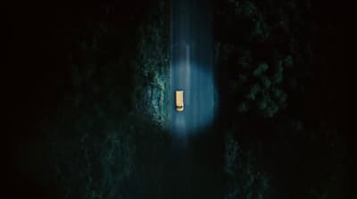 a car driving down a road in the dark