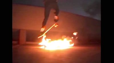a person jumping a skate board over a fire