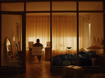 a person sitting at a desk in front of a window