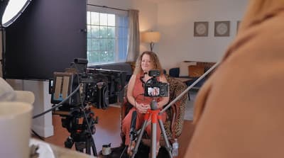 a woman sitting in a chair in front of a camera