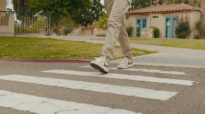 a person walking across a cross walk on a street