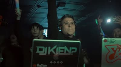 a man holding a laptop in front of a crowd of people