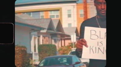 a man holding a sign in front of a house