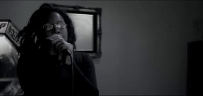 a woman with glasses singing into a microphone