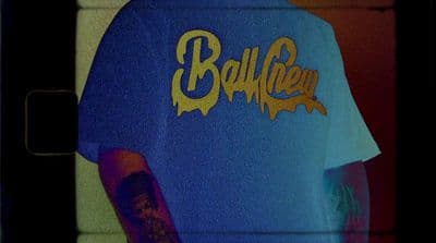 a blue shirt with gold lettering on it