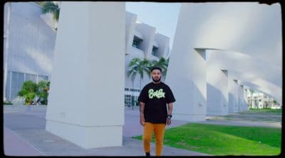 a man standing next to a tall white building