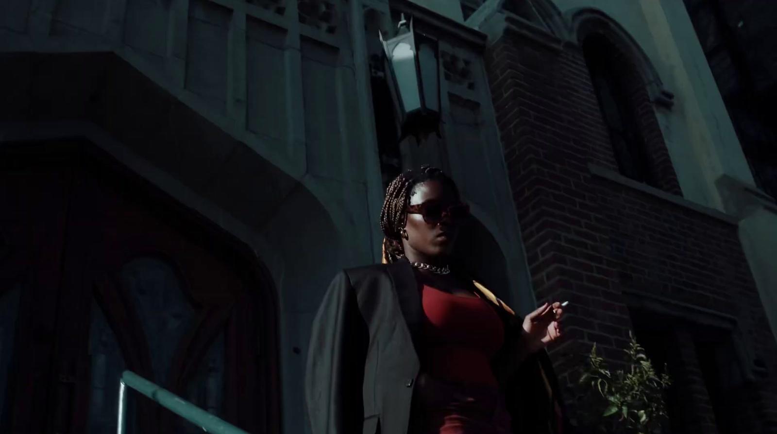 a woman in a red dress is standing outside a building