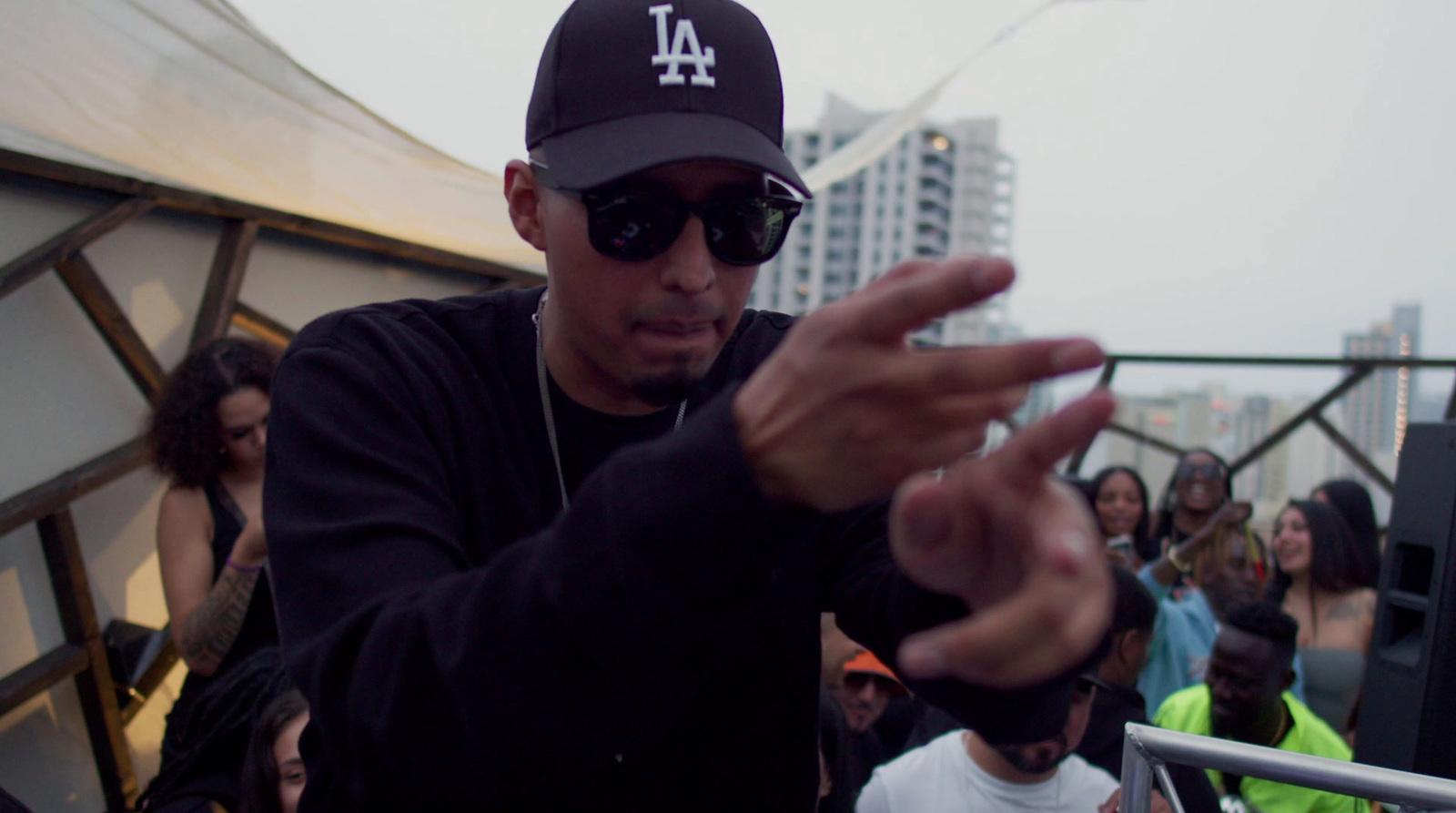 a man in a black hat and sunglasses holding a cell phone
