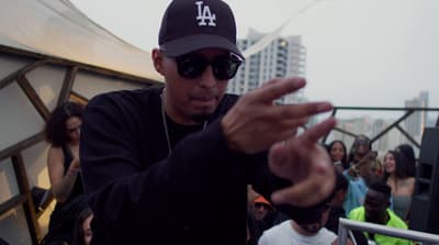 a man in a black hat and sunglasses holding a cell phone