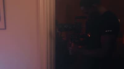 a man standing in a doorway holding a camera