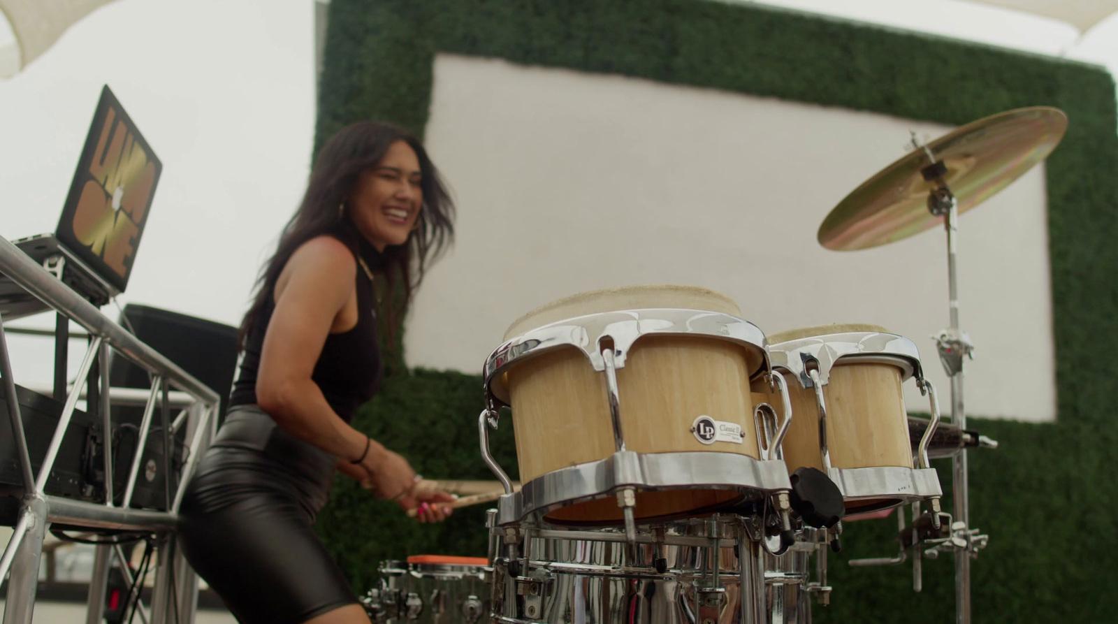 a woman is playing drums on a stage