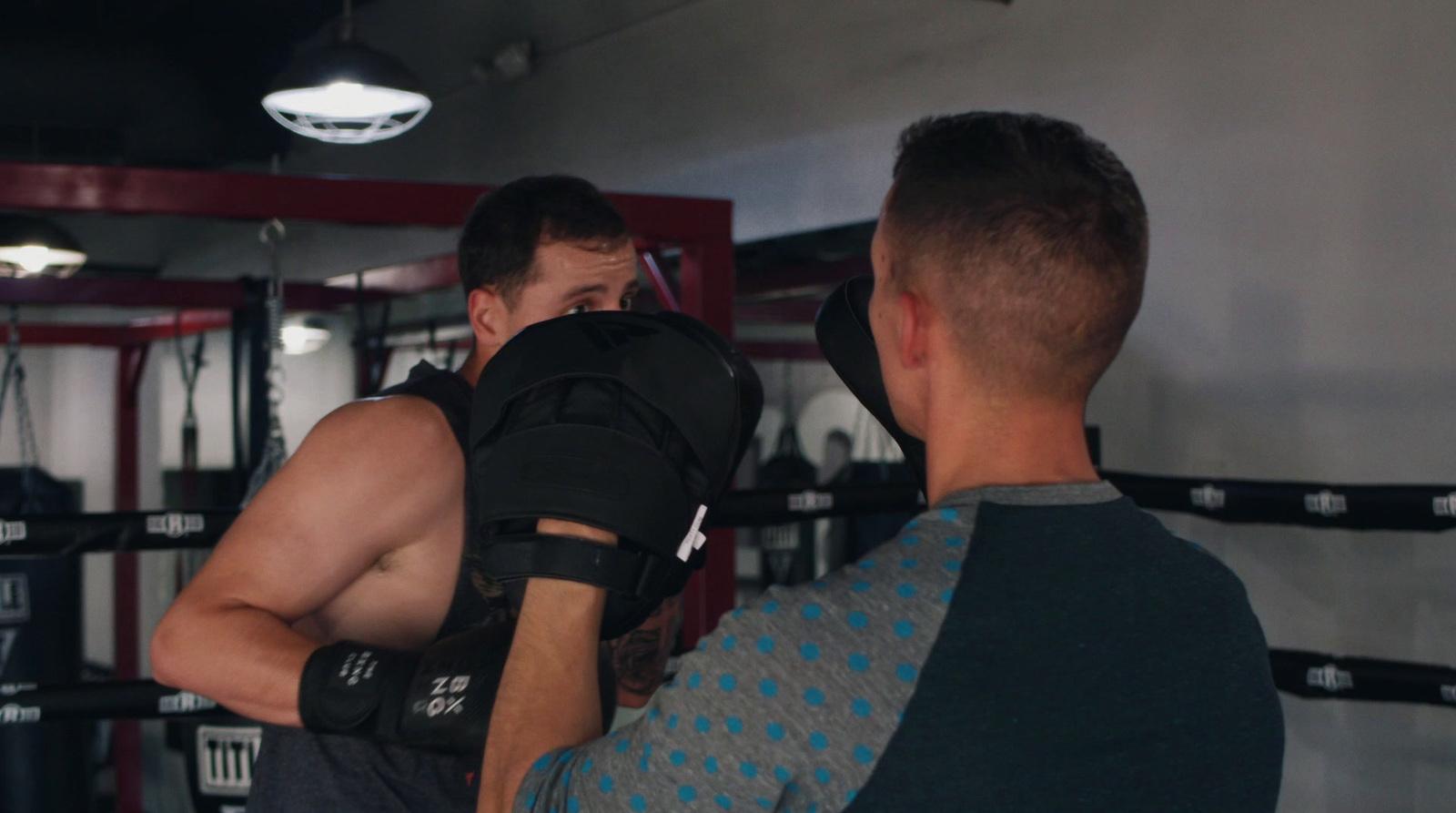 a couple of men standing in a gym