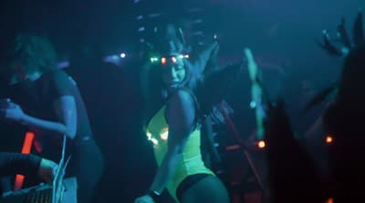 a woman in a yellow bodysuit on a stage