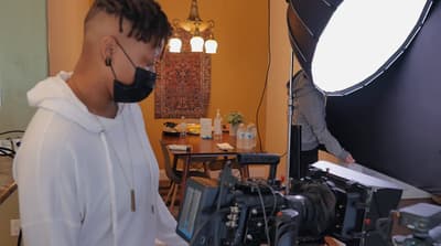 a man wearing a face mask in front of a camera