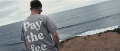 a man standing on top of a cliff next to the ocean