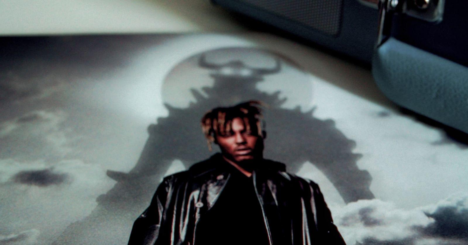 a man standing in front of a shadow of a demon