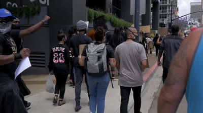 a group of people walking down a sidewalk