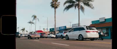 a white van driving down a street next to tall palm trees
