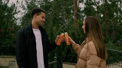 a man and a woman are holding orange drinks