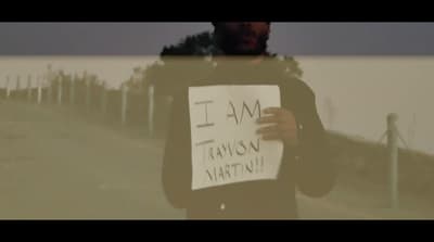 a man holding a sign in front of a window