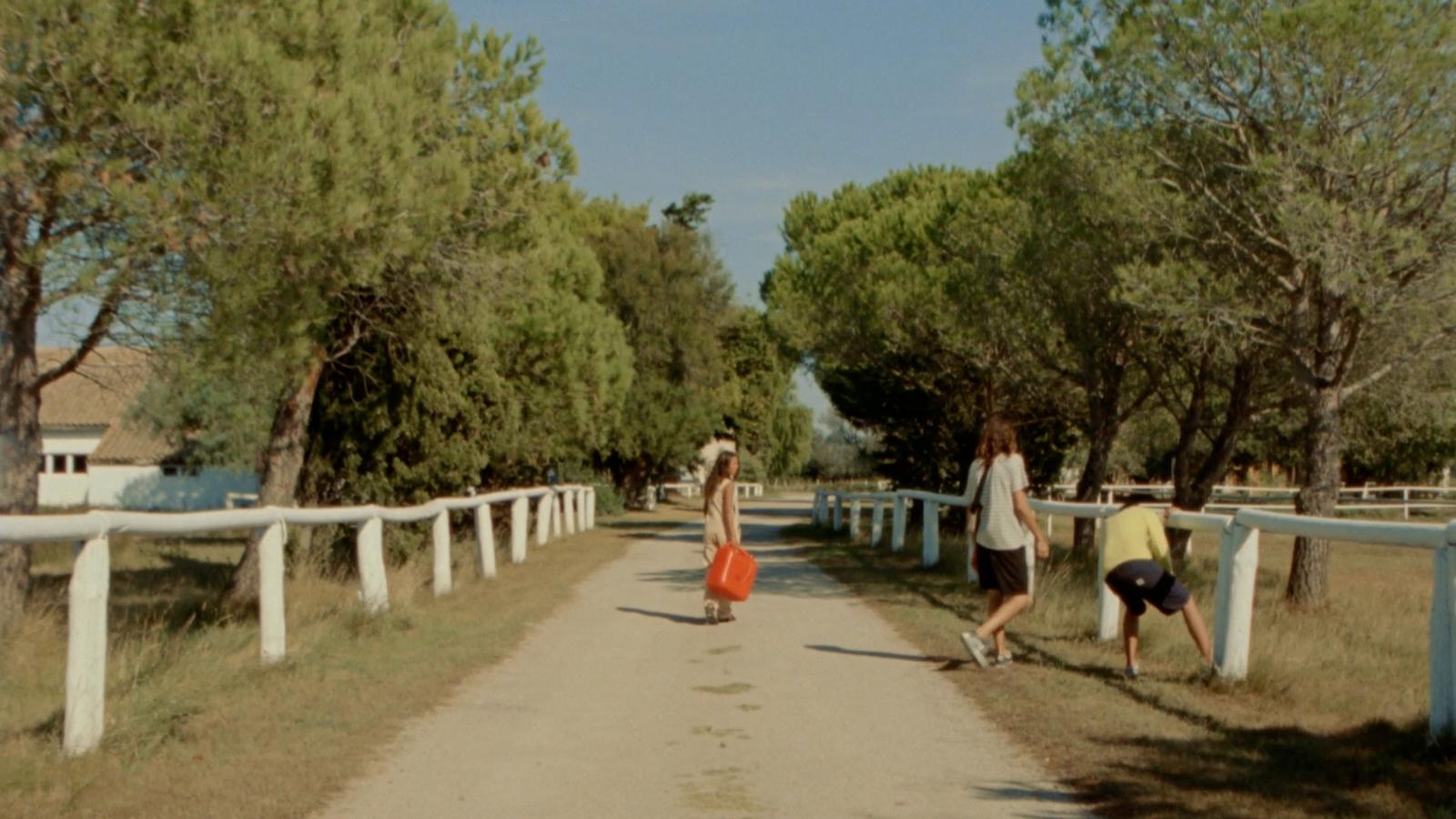 a couple of people walking down a dirt road
