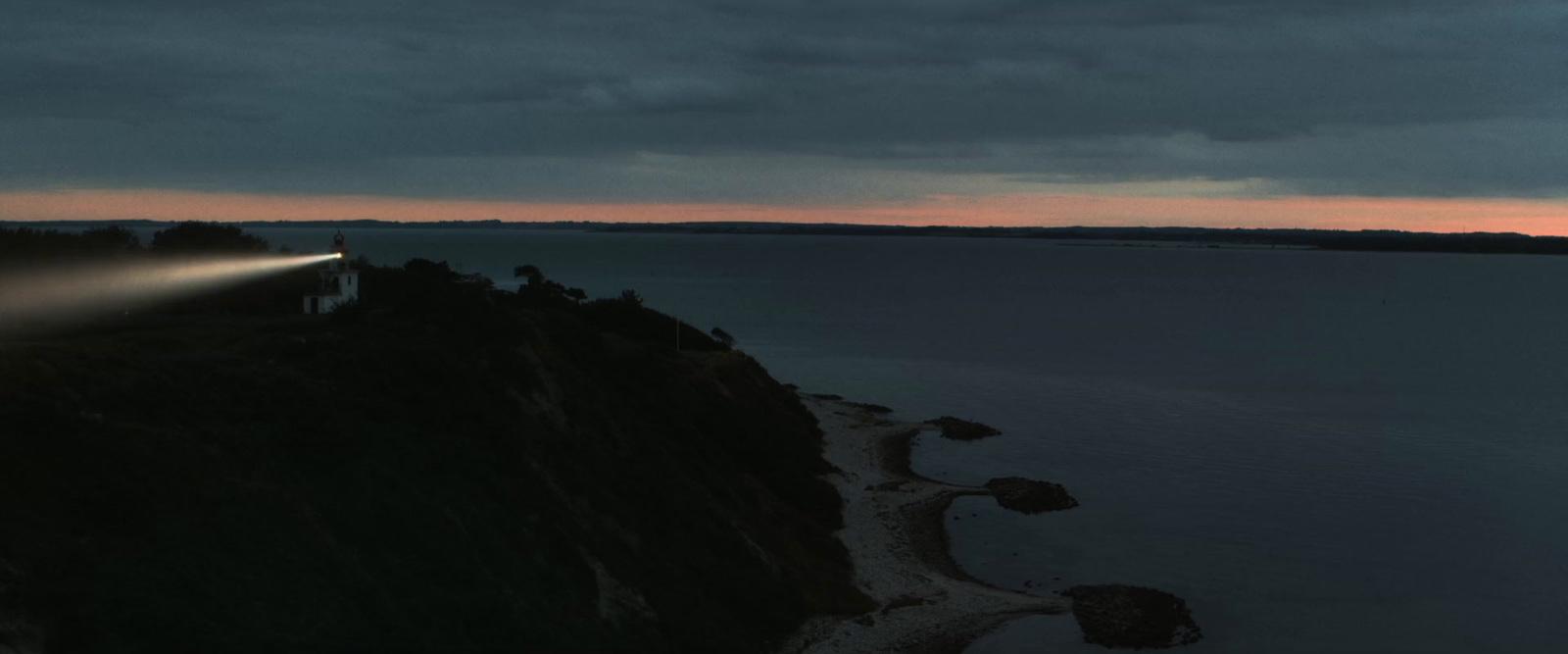 a lighthouse on top of a cliff at dusk