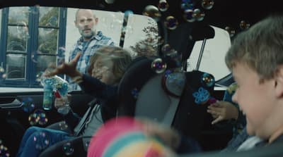 a group of children playing with bubbles in the back seat of a car