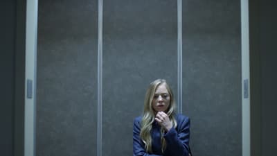 a woman in a suit sitting in a room