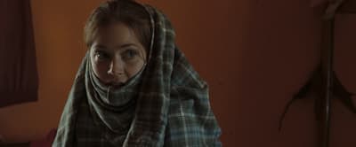 a woman wearing a plaid scarf in a room