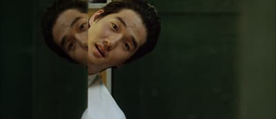 a man's face is reflected in a mirror