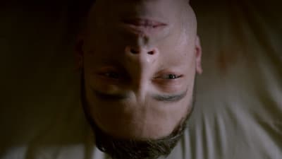 a man laying on a bed with his head in the air