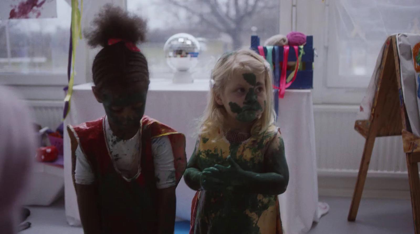 two children with paint on their faces standing next to each other