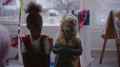 two children with paint on their faces standing next to each other