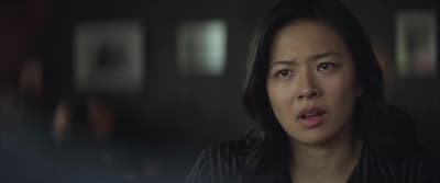 a woman is staring at something in a dark room