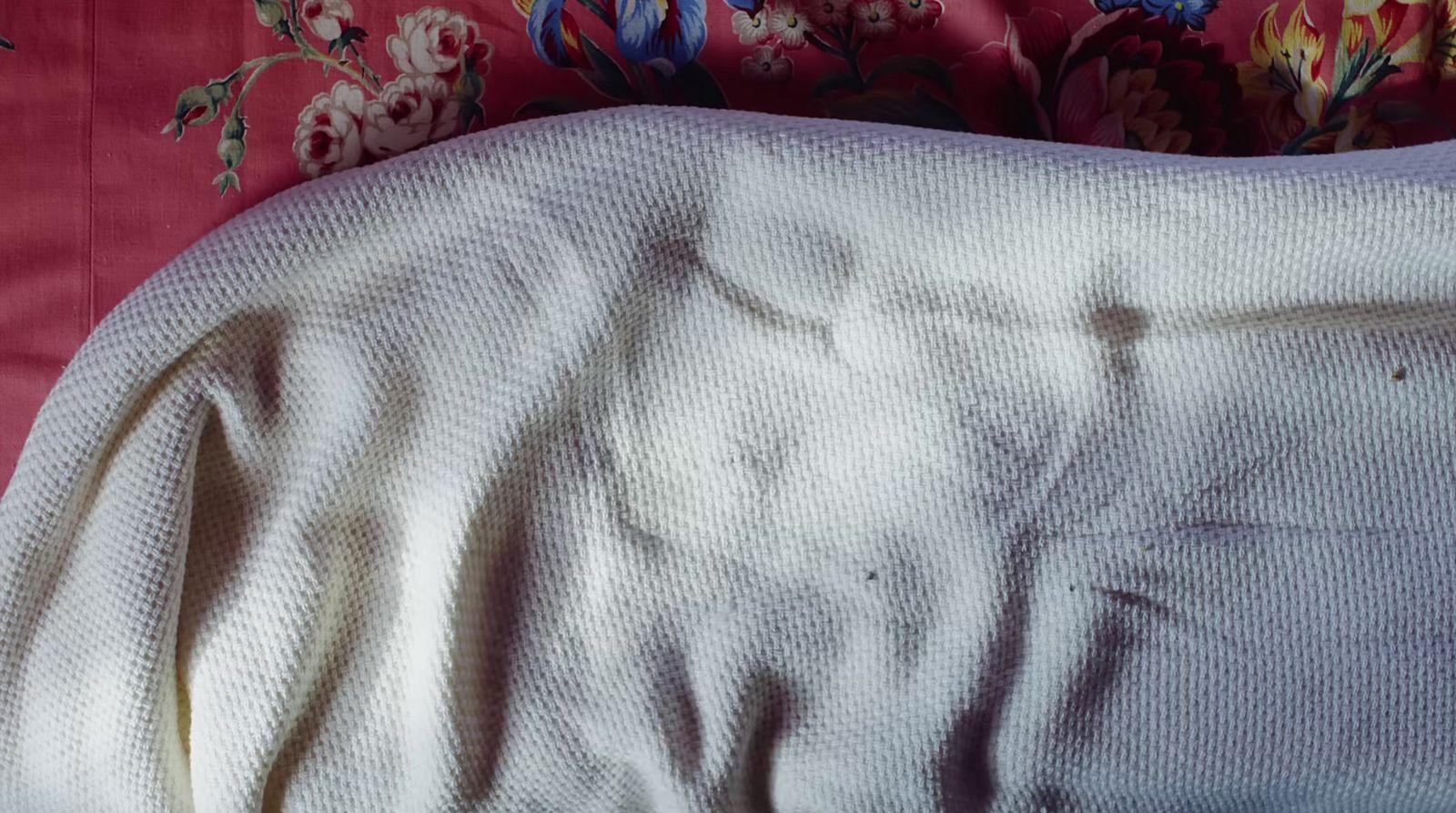 a bed with a white comforter on top of it