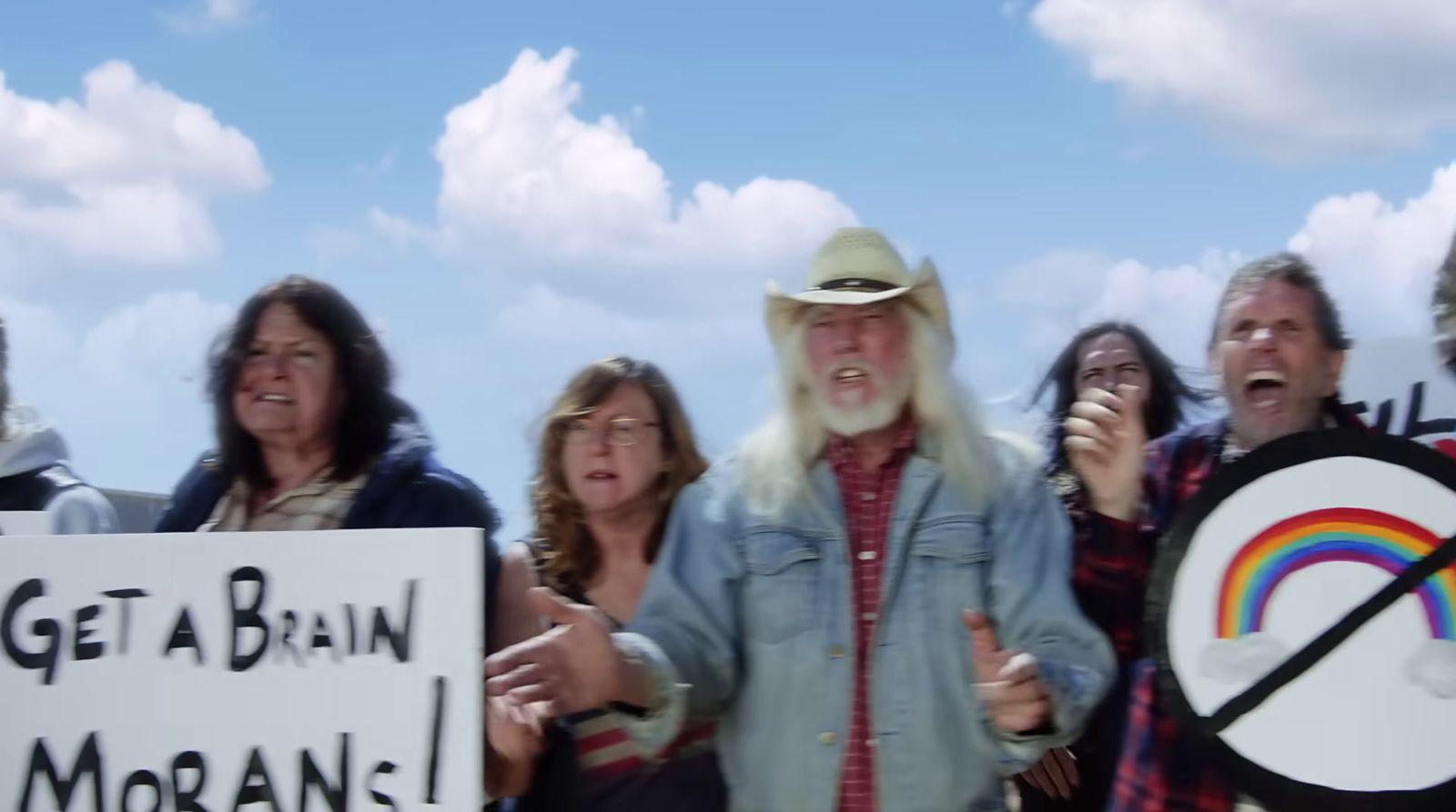 a group of people standing around each other holding signs