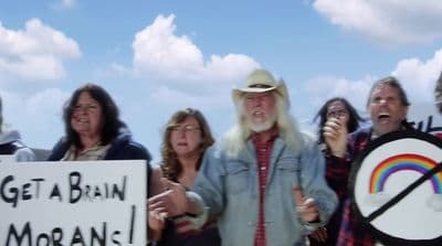 a group of people standing around each other holding signs