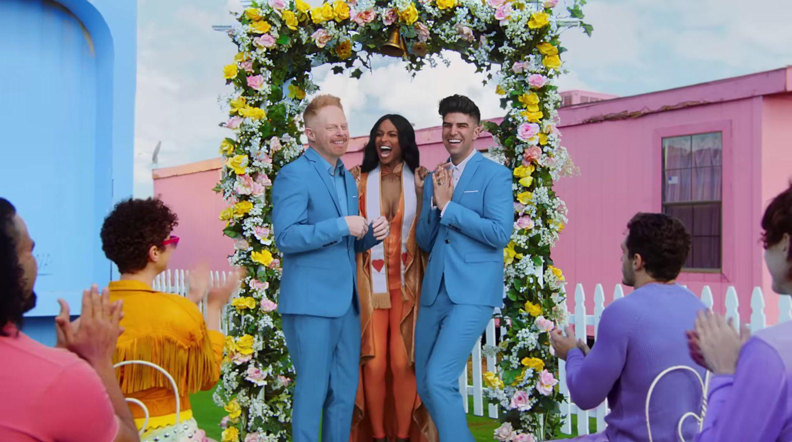 a couple of people that are standing in front of some flowers