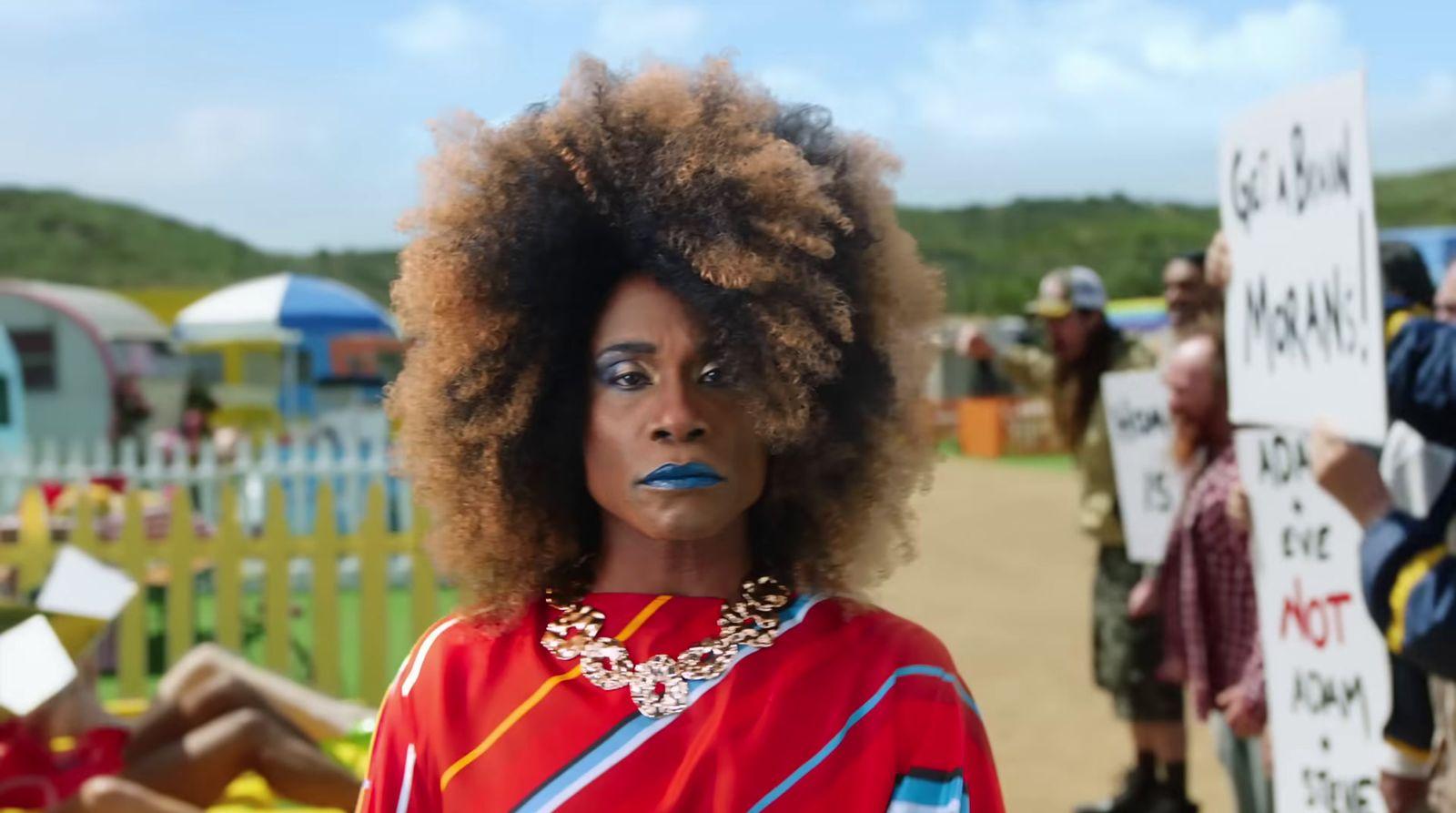 a woman with an afro standing in front of a group of people
